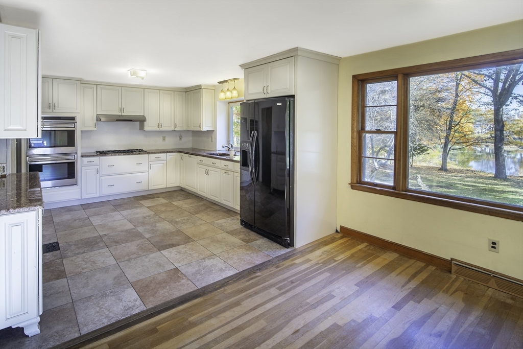 84 Bethany Road Framingham, MA 01702 - Photo 16 of 38 a large kitchen with cabinets wooden floor and stainless steel appliances