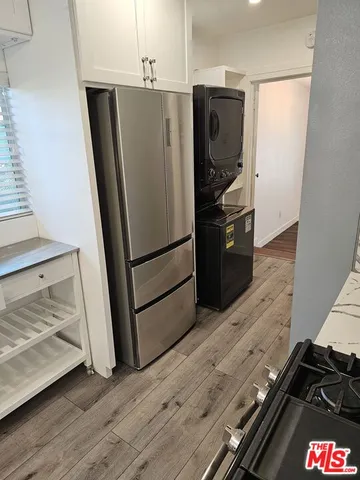 a kitchen with wooden floor and electronic appliances