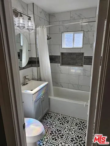 a bathroom with a sink a toilet a mirror a vanity and a shower