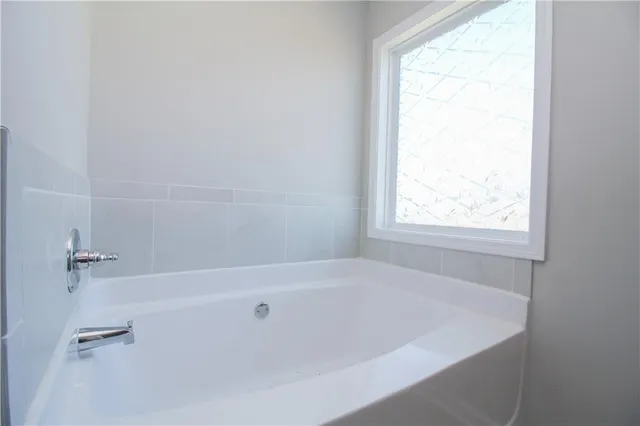 a white bath tub sitting next to a window