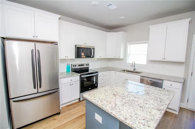 a kitchen with stainless steel appliances granite countertop a refrigerator stove microwave and sink