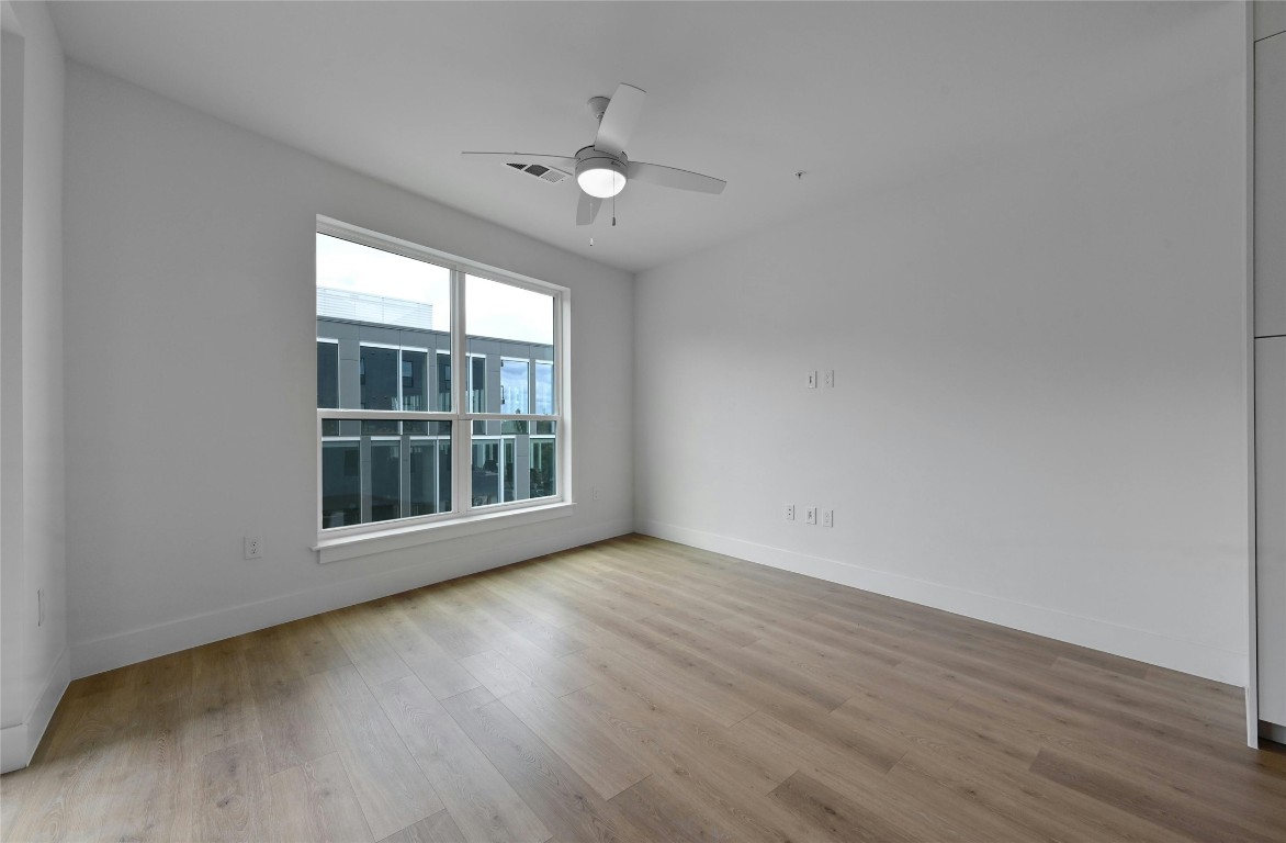1701 Simond Avenue, Unit 328 Austin, TX 78723 - Photo 12 of 35 an empty room with wooden floor and windows