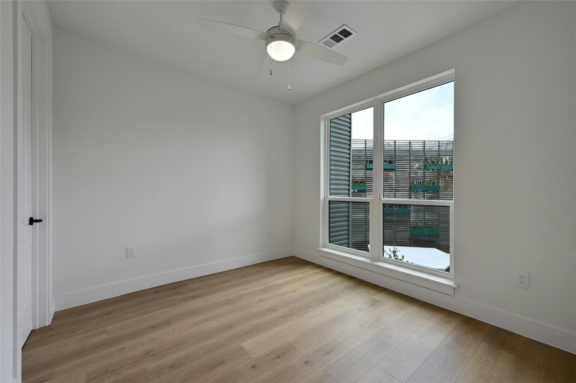 1701 Simond Avenue, Unit 328 Austin, TX 78723 - Photo 13 of 35 an empty room with wooden floor and windows