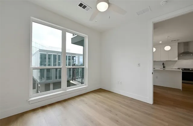an empty room with wooden floor and windows