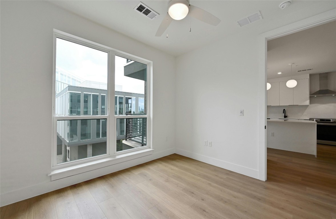 1701 Simond Avenue, Unit 328 Austin, TX 78723 - Photo 14 of 35 an empty room with wooden floor and windows