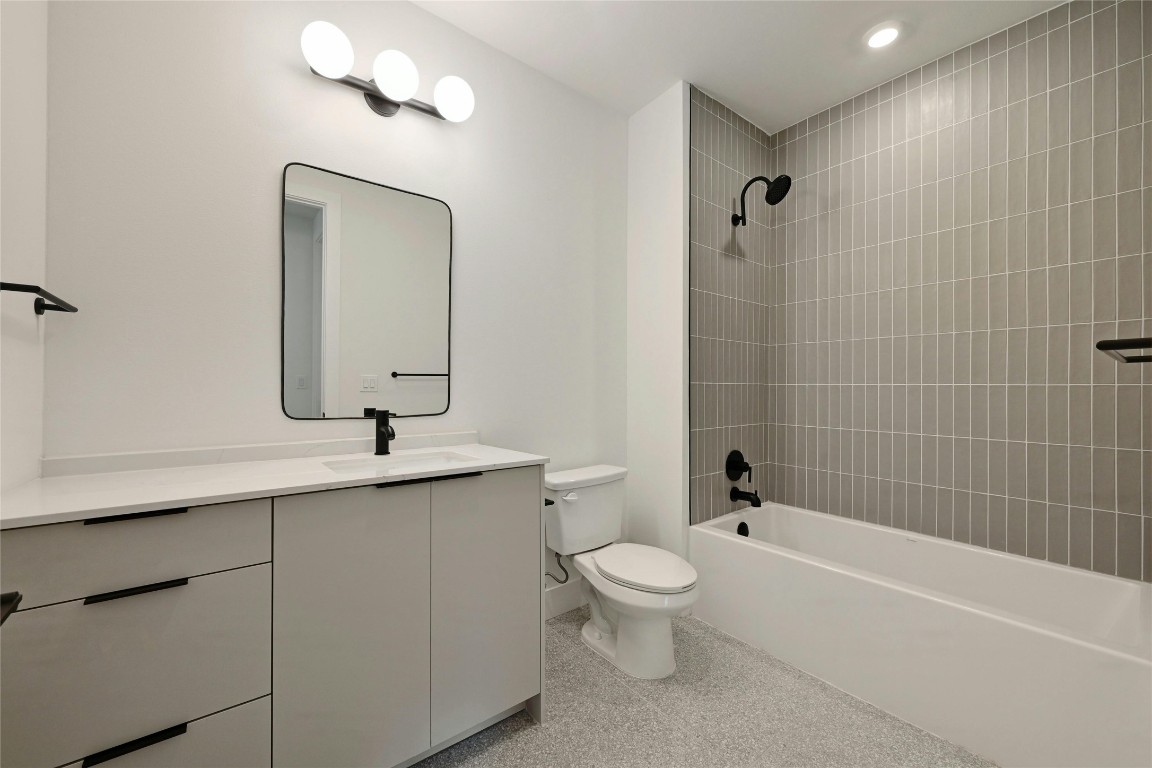 1701 Simond Avenue, Unit 328 Austin, TX 78723 - Photo 18 of 35 a bathroom with a toilet a sink a mirror a bathtub and shower