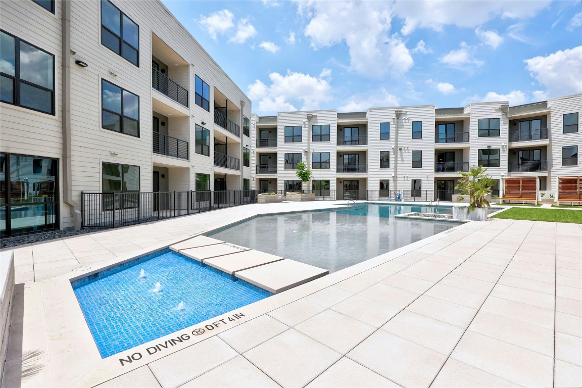 1701 Simond Avenue, Unit 328 Austin, TX 78723 - Photo 27 of 35 a view of a swimming pool with a lounge chairs in front of building