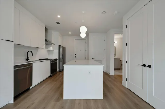 a kitchen with cabinets and wooden floor