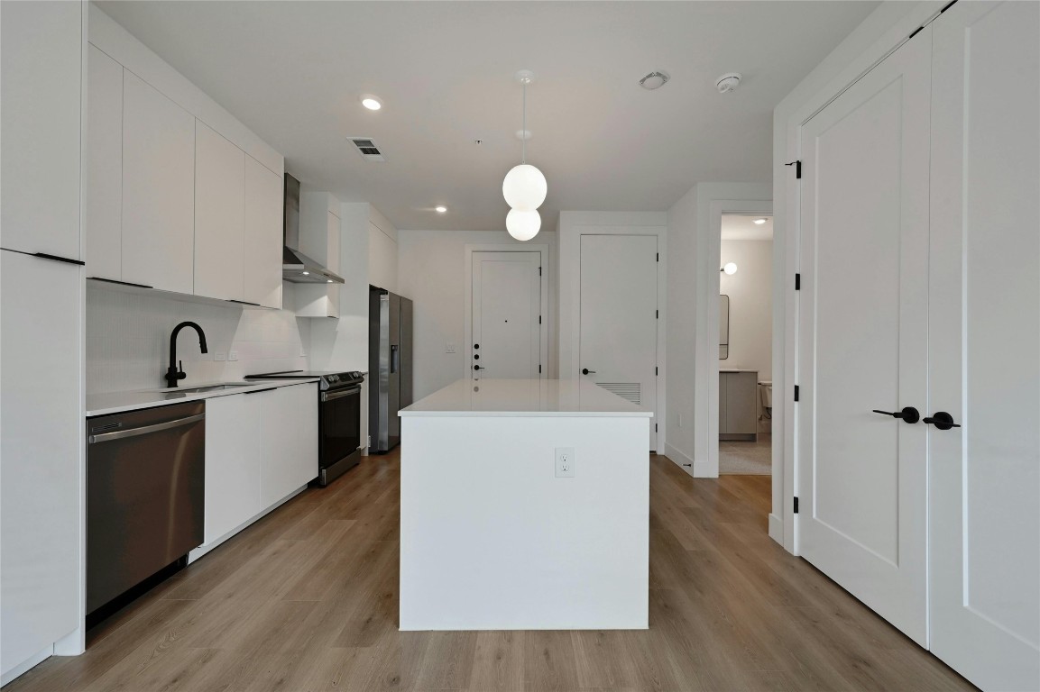 1701 Simond Avenue, Unit 328 Austin, TX 78723 - Photo 7 of 35 a kitchen with cabinets and wooden floor