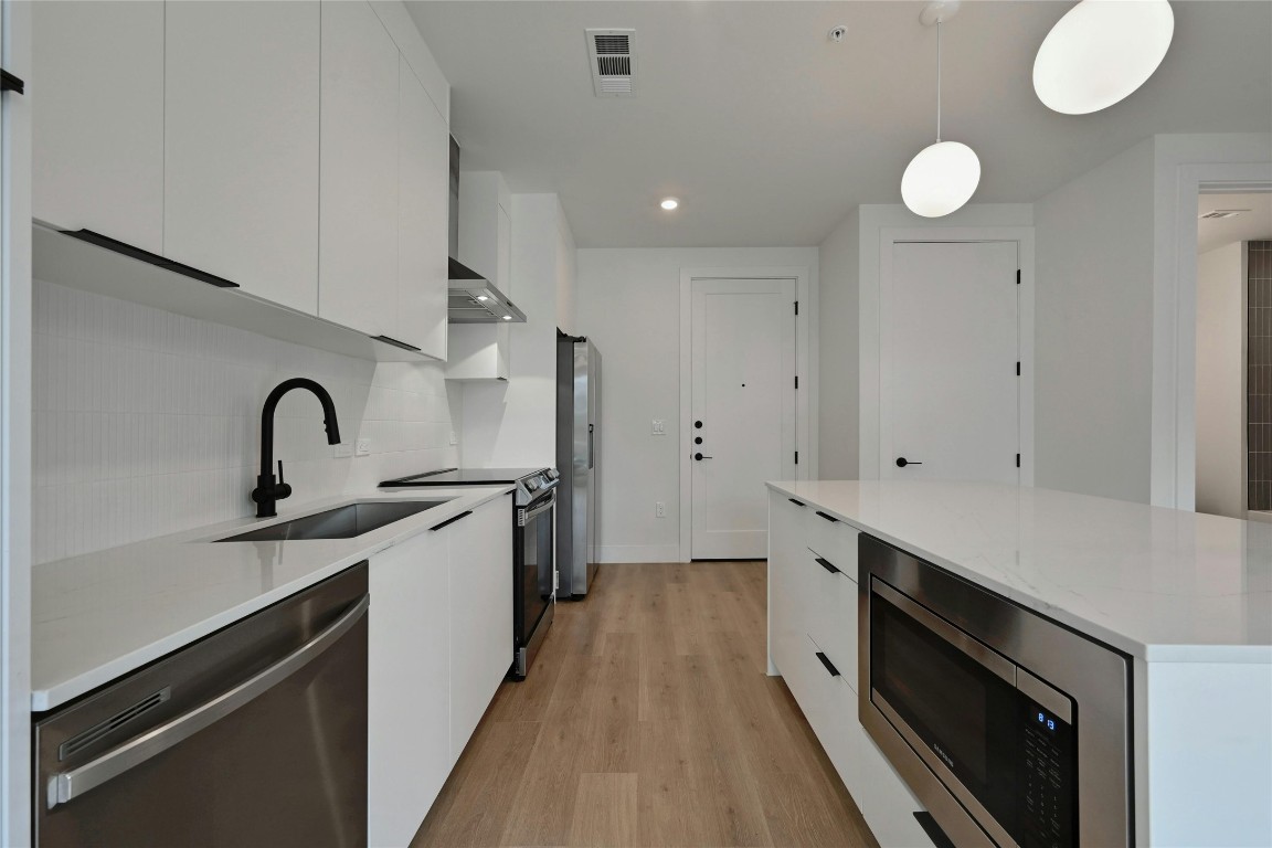1701 Simond Avenue, Unit 328 Austin, TX 78723 - Photo 8 of 35 a kitchen with a sink stainless steel appliances and cabinets