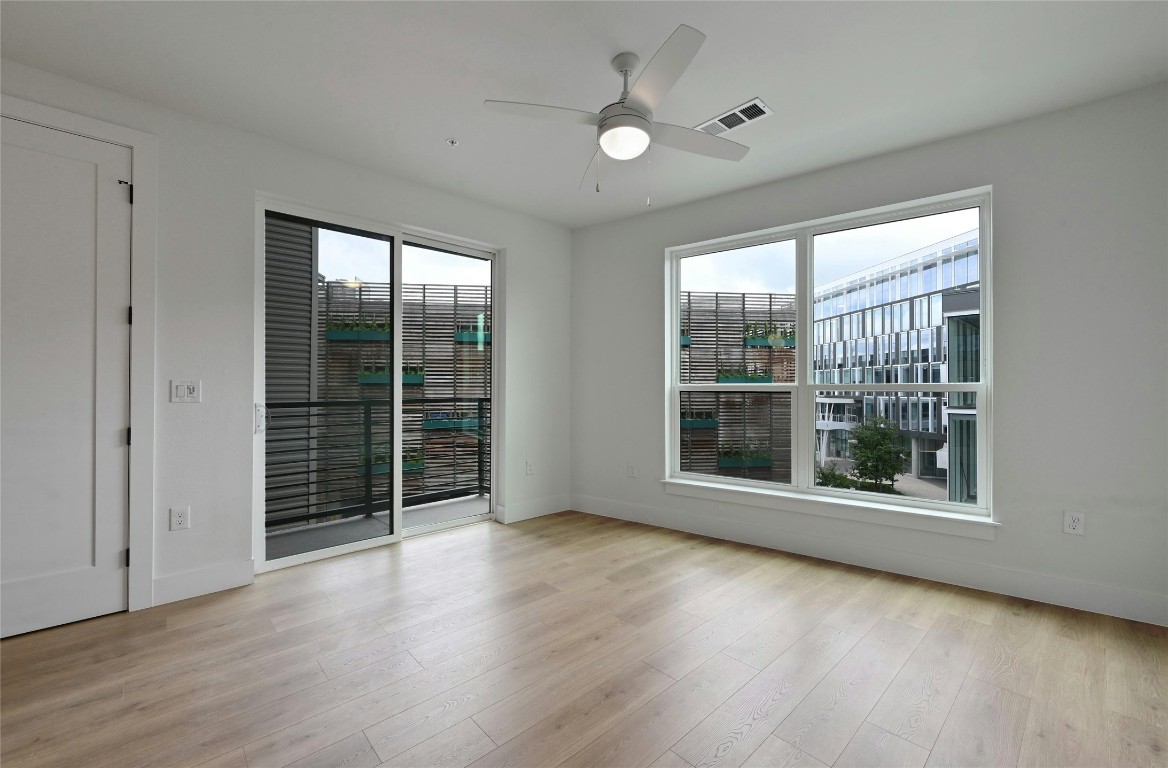 1701 Simond Avenue, Unit 328 Austin, TX 78723 - Photo 9 of 35 a view of an empty room with wooden floor and fan with window