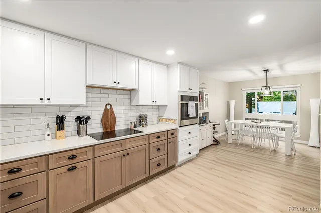 a kitchen with white cabinets sink and white stainless steel appliances