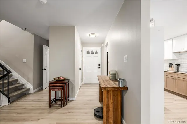 a view of a hallway to room with wooden floor and furniture