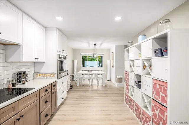a large white kitchen with stainless steel appliances