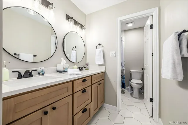 a bathroom with a granite countertop toilet sink and a mirror