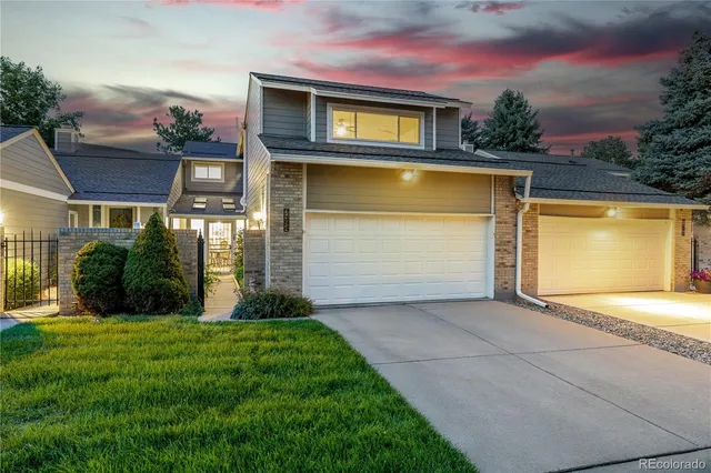 a view of a house with a yard and potted plants
