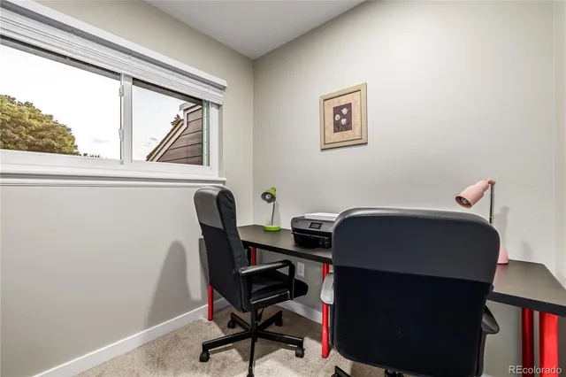 a view of a workspace with furniture and a window