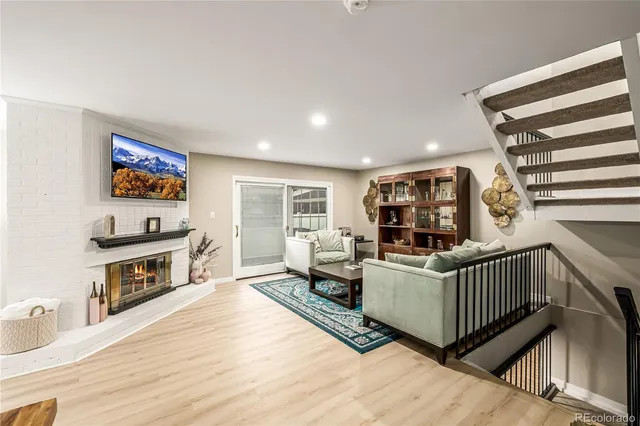 a living room with furniture a flat screen tv and a wooden floor