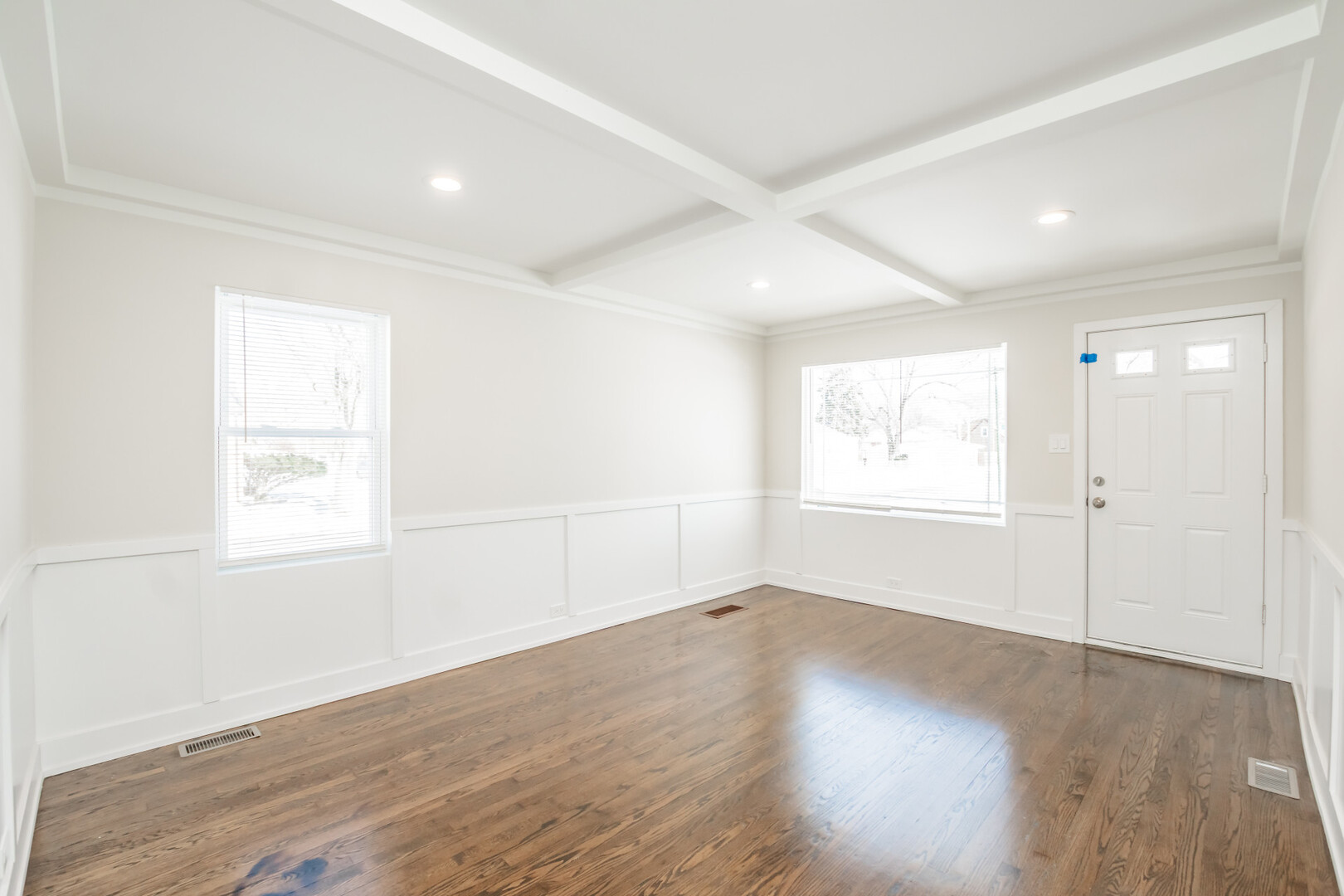 9800 South Drexel Avenue Chicago, IL 60628 - Photo 2 of 16 an empty room with wooden floor and windows