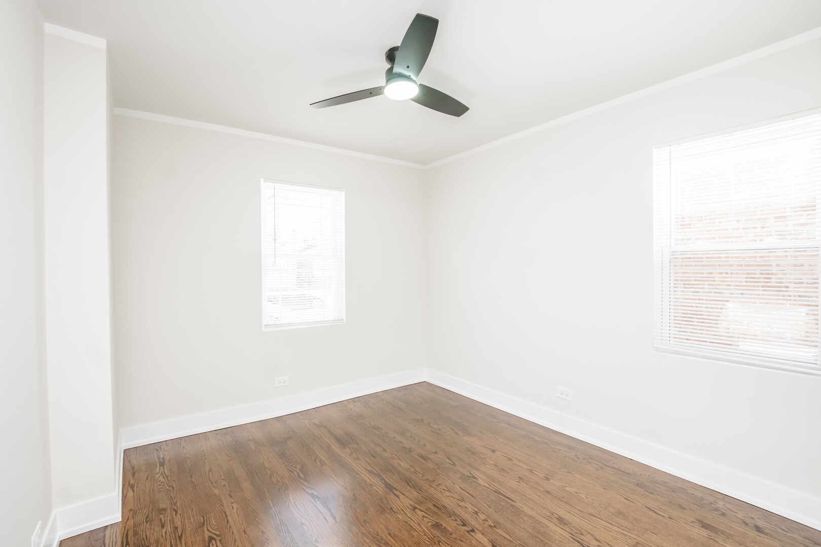 9800 South Drexel Avenue Chicago, IL 60628 - Photo 10 of 16 a view of a room with wooden floor and a ceiling fan