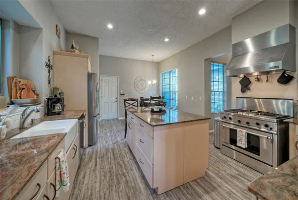 a kitchen with stainless steel appliances granite countertop a lot of counter top space and wooden floor
