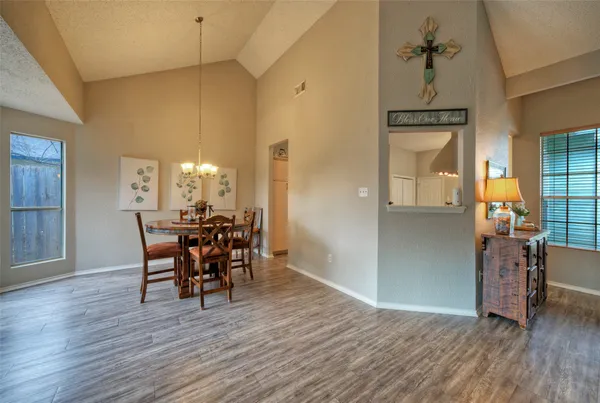 a dining room with furniture a chandelier and wooden floor
