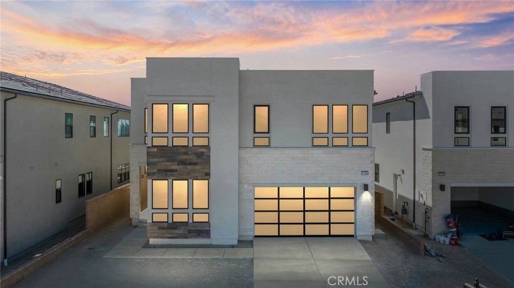 a front view of a house with a large tree