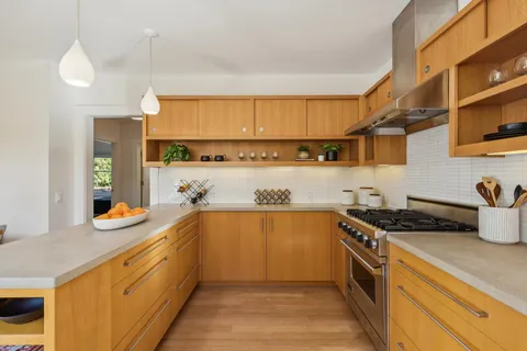 a bathroom with a granite countertop sink a bathtub and a window
