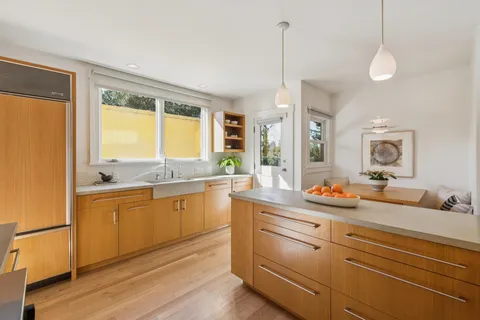 a kitchen with a sink and wooden floor