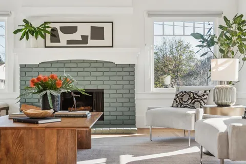 a living room with furniture a potted plant and a fireplace