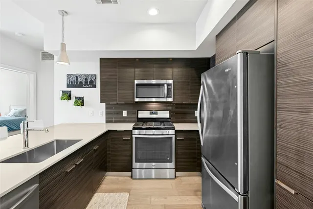 a kitchen with stainless steel appliances granite countertop a refrigerator and a sink