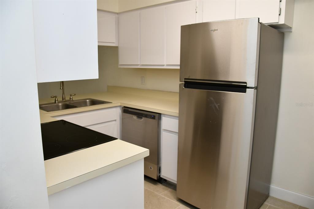 2635 Southwest 35th Place, Unit 1302 Gainesville, FL 32608 - Photo 4 of 17 a kitchen with a refrigerator sink and cabinets