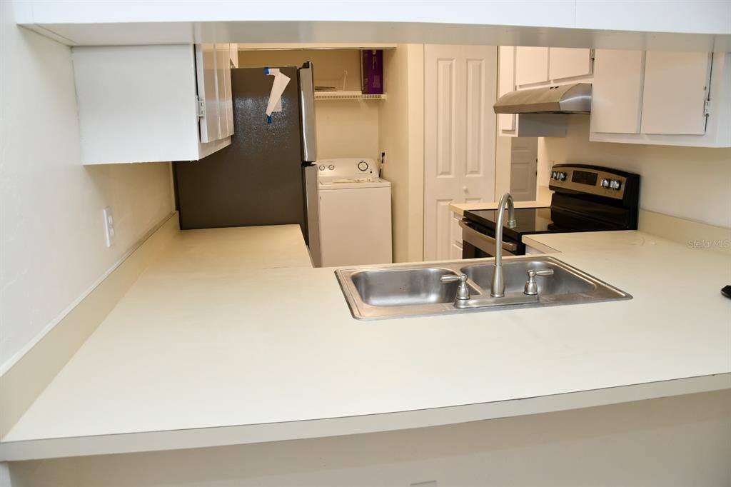 2635 Southwest 35th Place, Unit 1302 Gainesville, FL 32608 - Photo 5 of 17 a close view of a sink a refrigerator and a stove