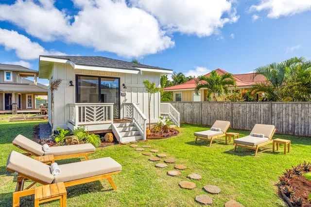 a front view of a house with garden and sitting area