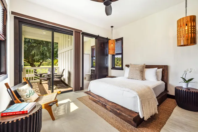 a bedroom with a bed and large windows