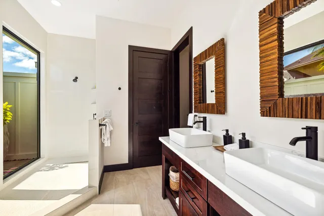 a bathroom with a double vanity sink mirror and shower