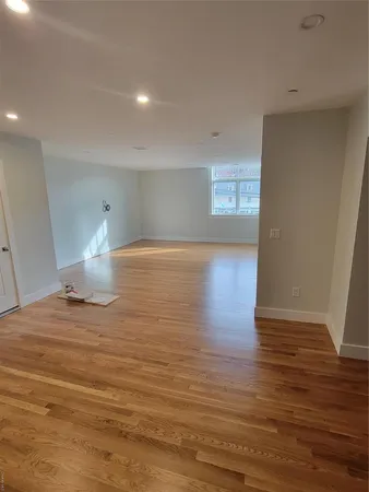 a view of empty room with wooden floor