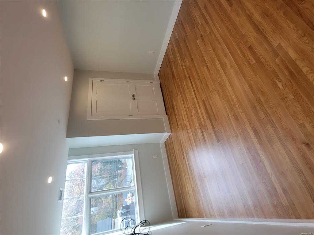 731 Broadway, Unit 4 Valhalla, NY 10595 - Photo 19 of 25 an empty room with wooden floor and windows