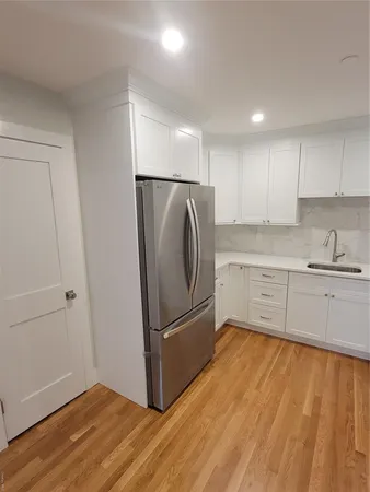 a kitchen with granite countertop a refrigerator and a sink