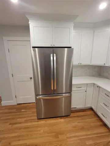 a metallic refrigerator freezer sitting in a kitchen