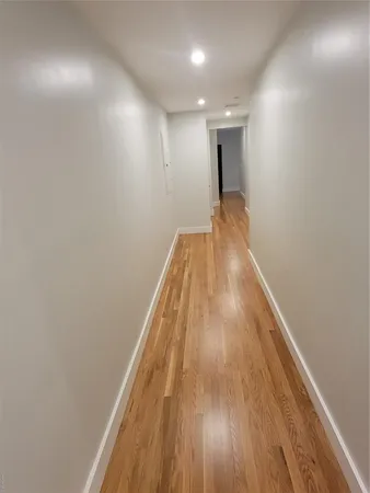 a view of hallway with wooden floor