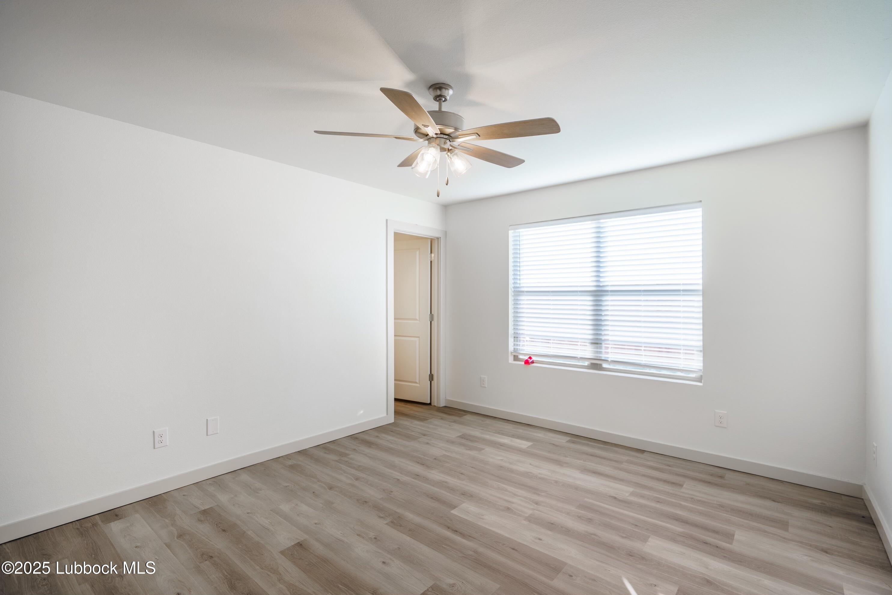 8013 Date Avenue Lubbock, TX 79404 - Photo 5 of 12 an empty room with a window and a ceiling fan
