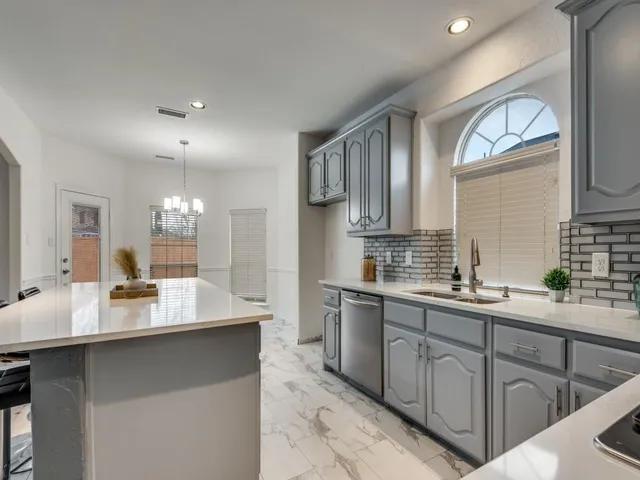a kitchen with counter top space sink and cabinets