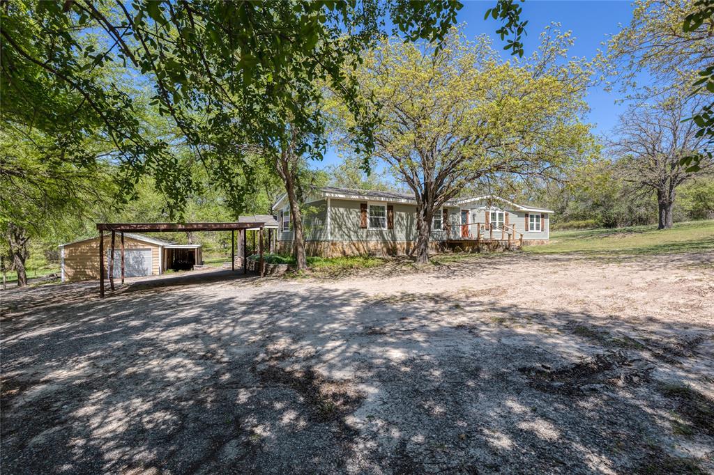 1701 Central Road Weatherford, TX 76088 - Photo 33 of 40 View of front facade with a workshop, driveway, and a carport.
