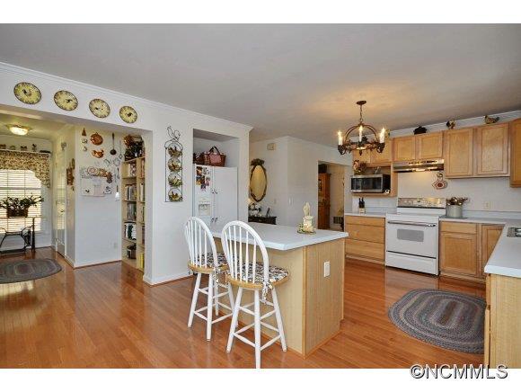 30 Splendor Ridge Waynesville, NC 28785 - Photo 5 of 23 a kitchen with stainless steel appliances kitchen island granite countertop a refrigerator a stove a sink and white cabinets with wooden floor