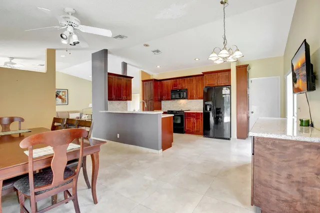 a view of a kitchen with granite countertop stainless steel appliances cabinets and a chandelier
