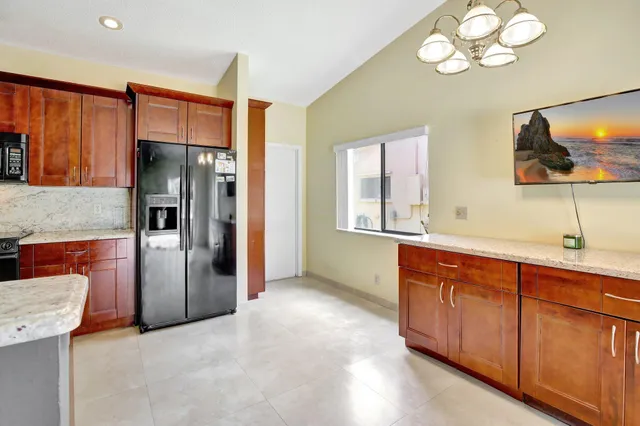 a view of kitchen with stainless steel appliances granite countertop a refrigerator and a sink