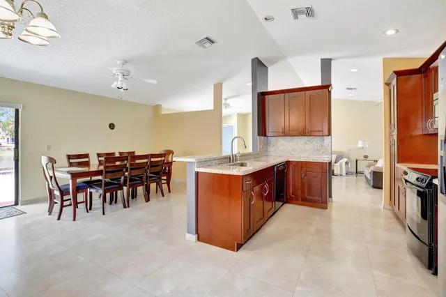 a large kitchen with cabinets table and chairs
