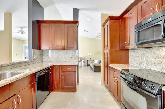 a kitchen with stainless steel appliances granite countertop a stove a sink and a microwave