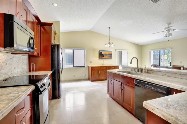 a kitchen with stainless steel appliances granite countertop a sink a stove and a refrigerator